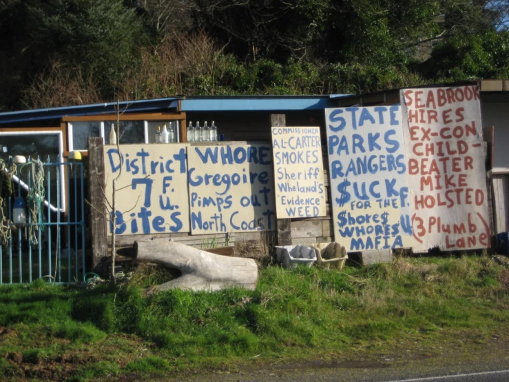 several signs are set up around a fence on the grass