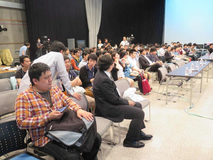 several people in a meeting room listening to a speaker