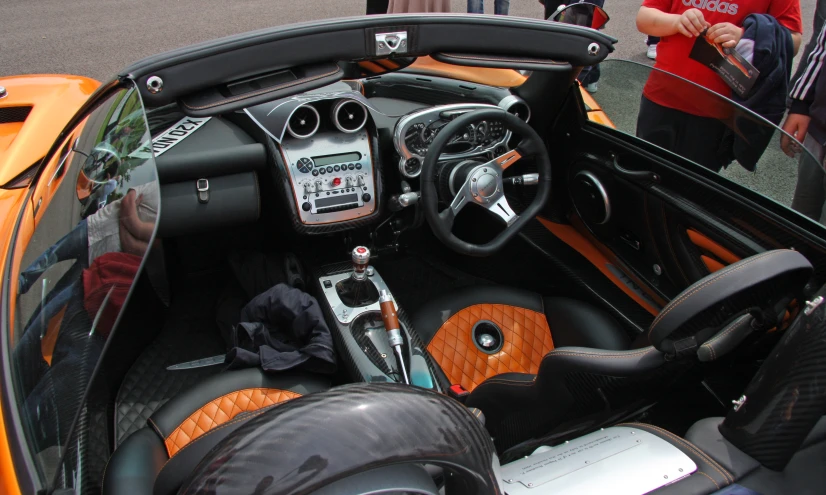 the interior of a car with orange and black stitchs