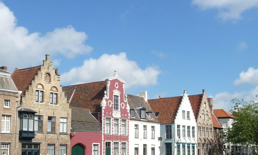 several colorful houses lined up with trees in front of them