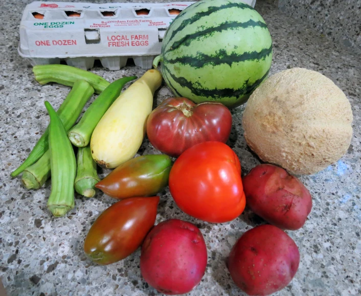 some fresh fruit and vegetables are on the granite