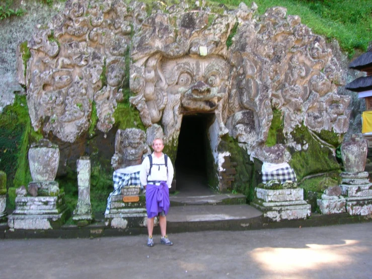 the person is posing for the camera in front of a strange looking structure