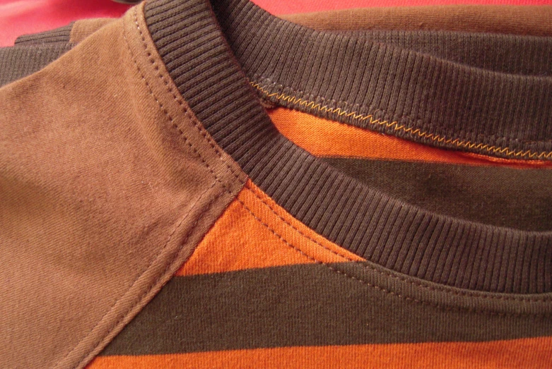 a person wearing an orange and black shirt with striped collar