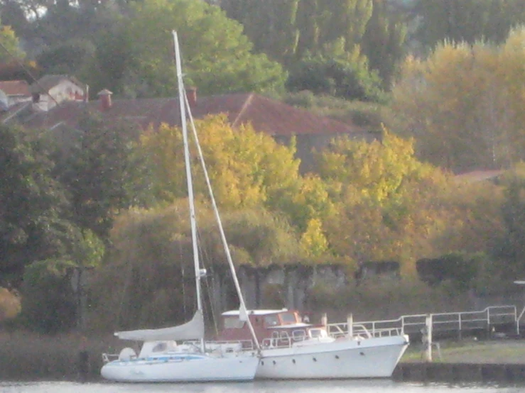 the white boat is docked outside on the water