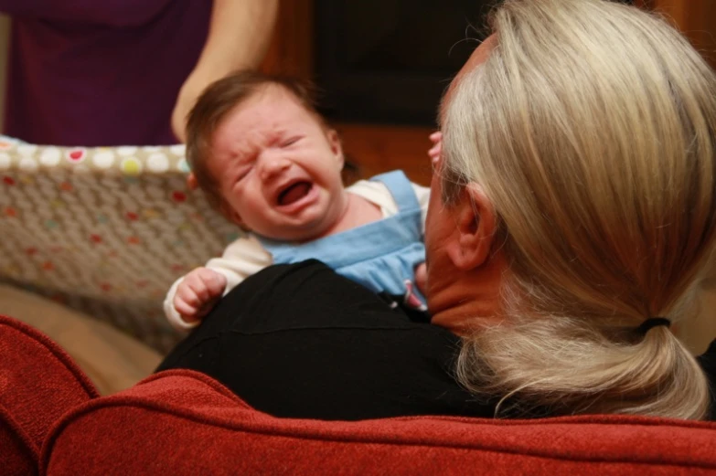 a baby crying in its mother's lap