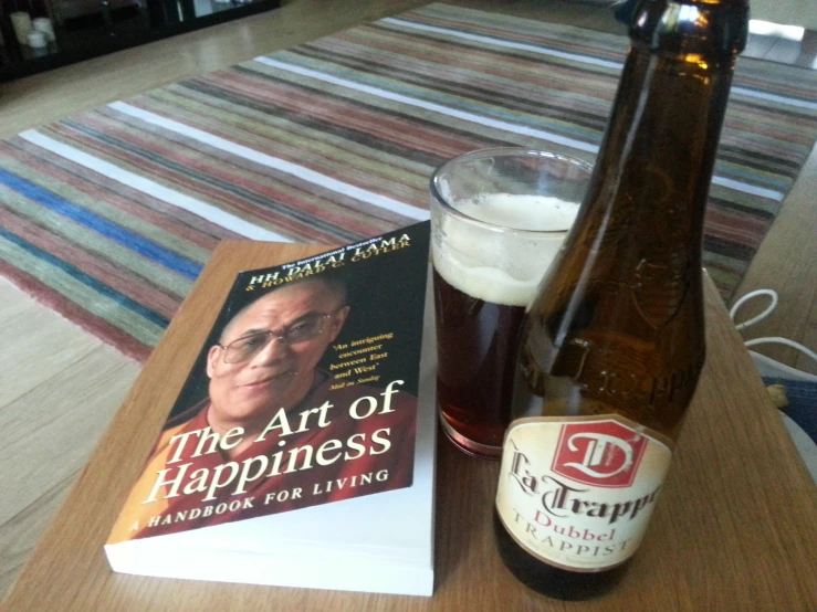 a bottle of beer, and book sitting on top of a table