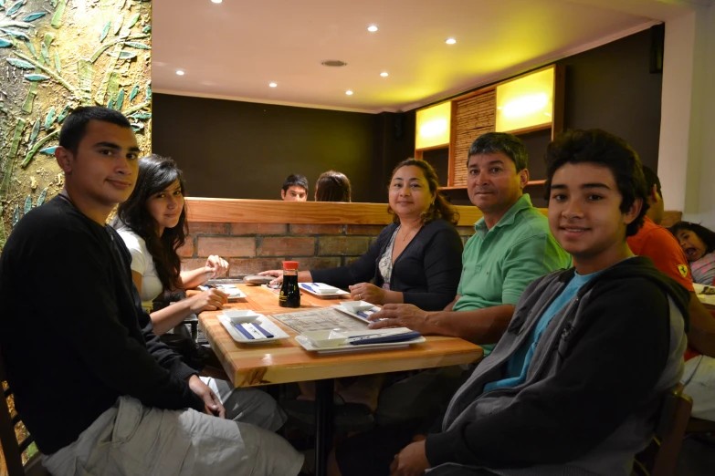 several people sitting around a table in a restaurant