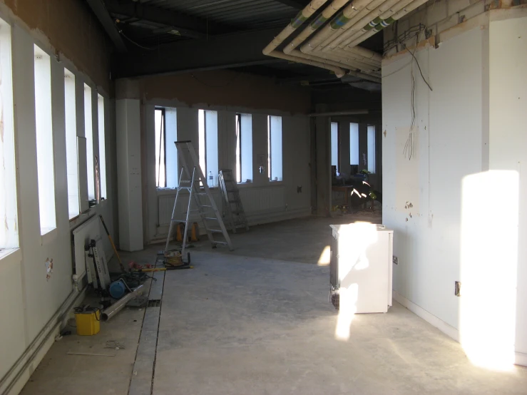 a view of a room being remodeled with the sun shining through the windows