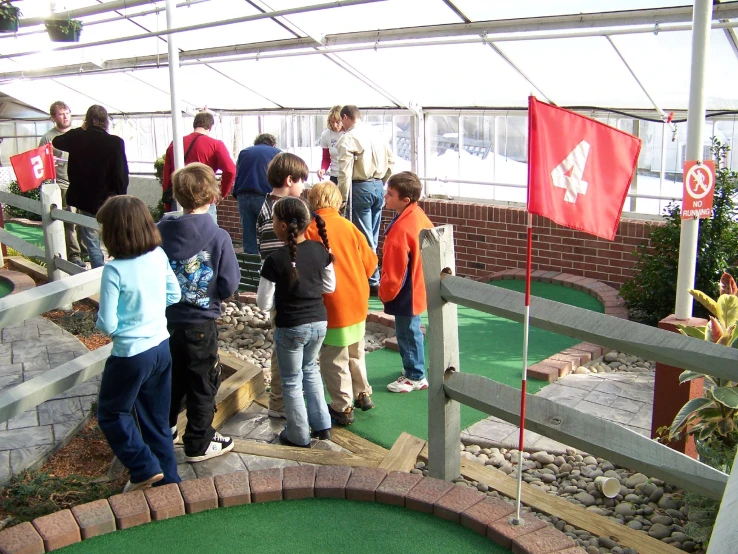 a group of people standing on top of a miniature golf course