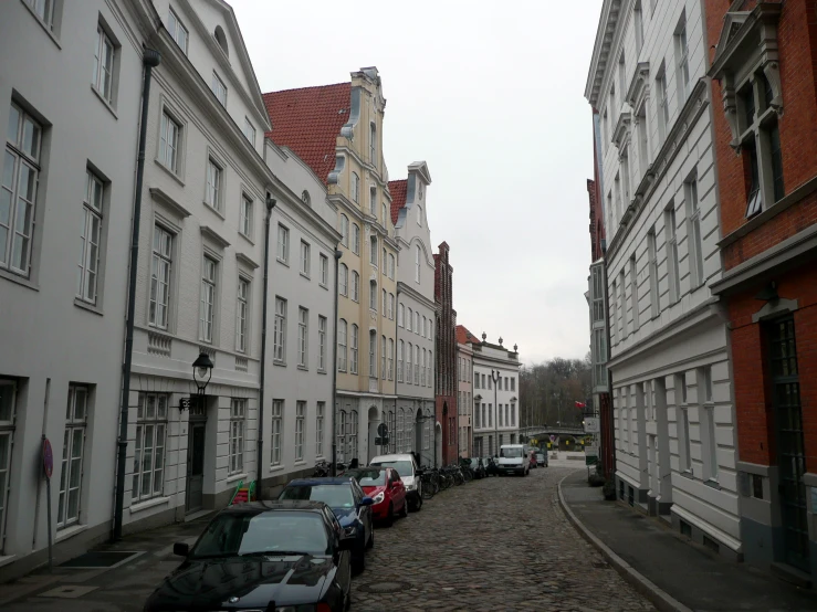 cars are parked along the side of the buildings