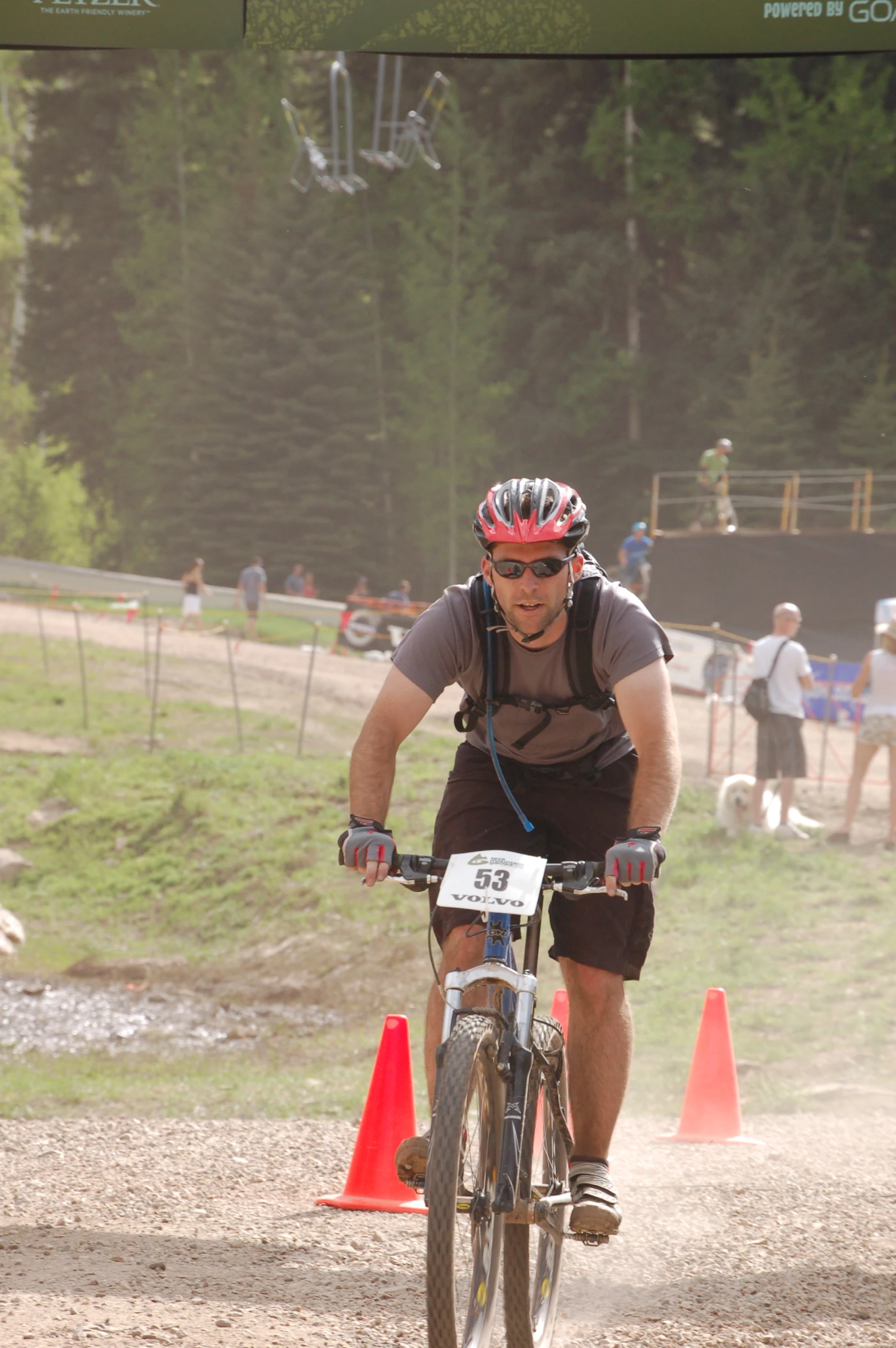 a man in brown riding a bike on top of a dirt trail