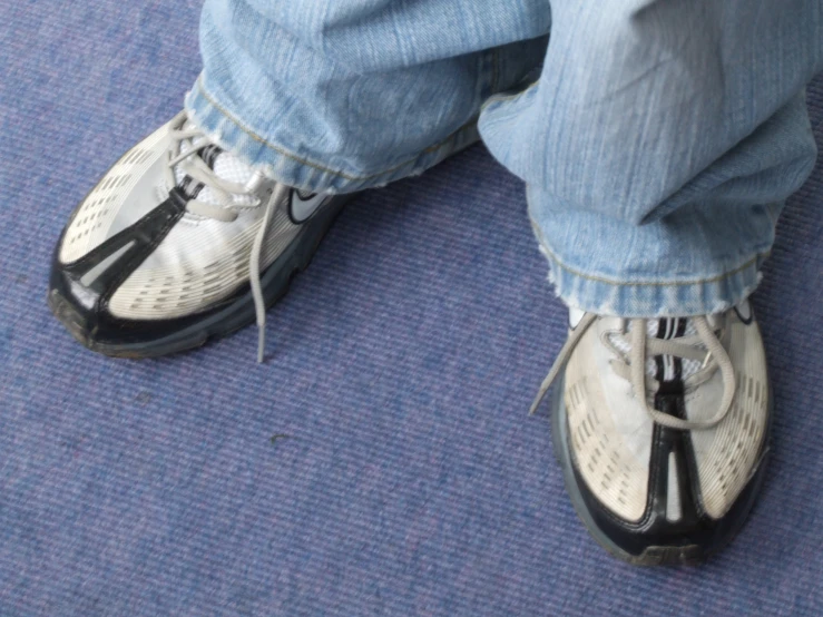 an extreme closeup s of a pair of jeans with blue jeans and white shoes