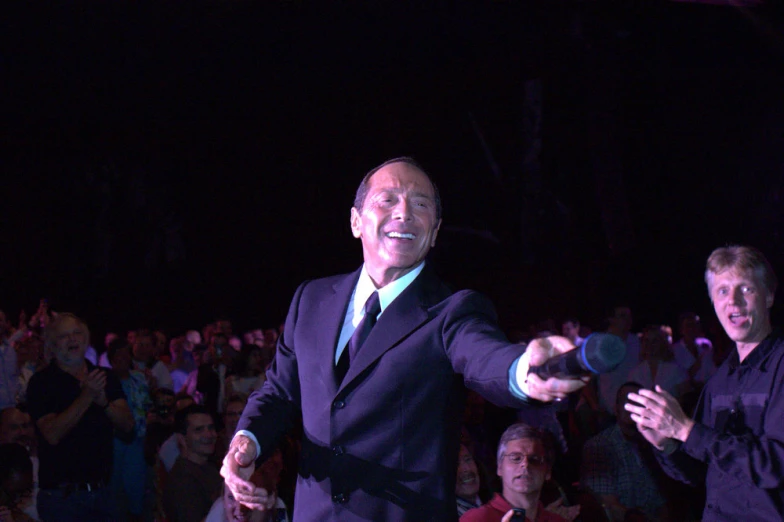 man in suit with green and blue tie at night