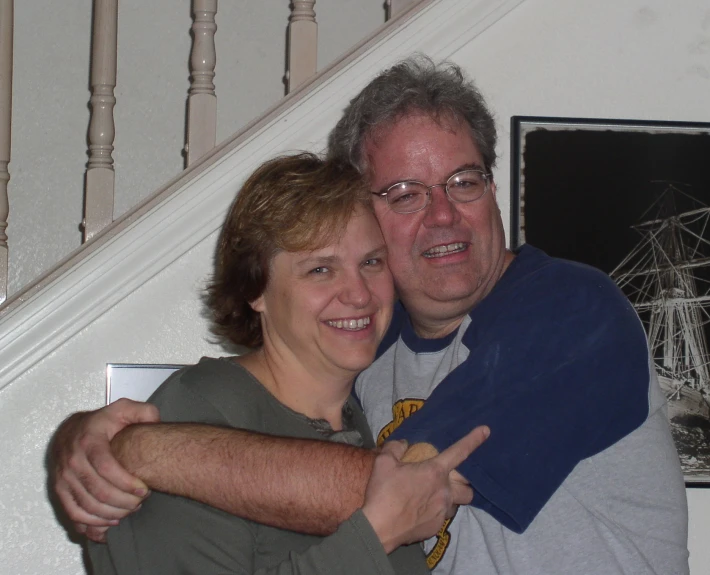 a man in glasses and a woman giving the thumbs up for a picture