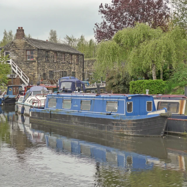 two blue boats in the water next to some trees