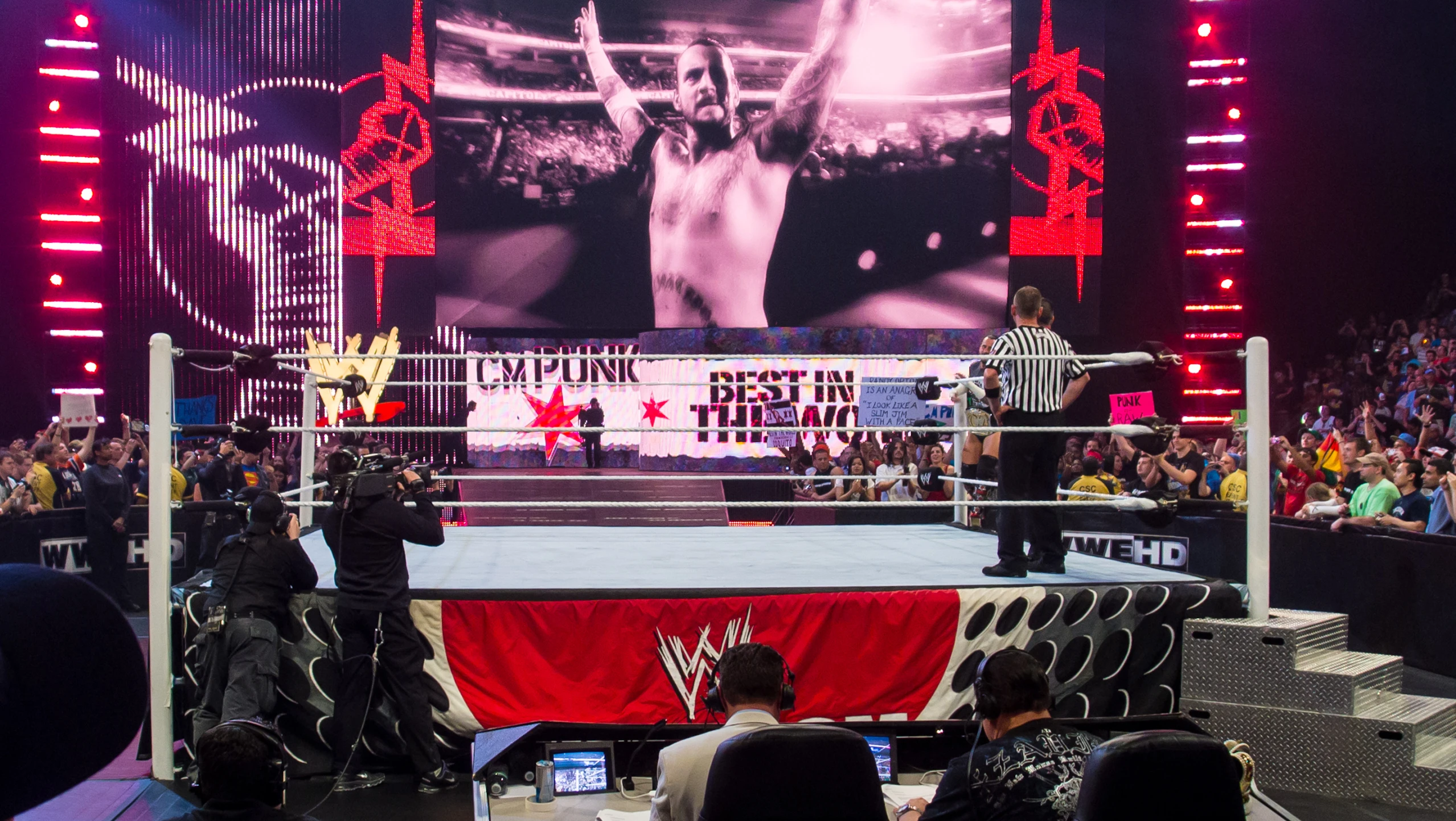 wrestlers are standing on the ring at night