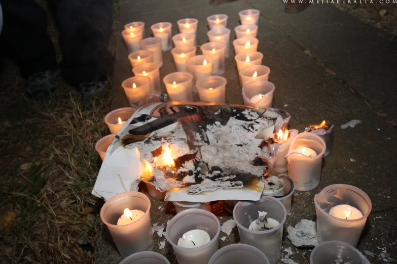 a group of white candles burning next to a cake