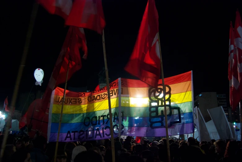 people in the street holding flags and a balloon