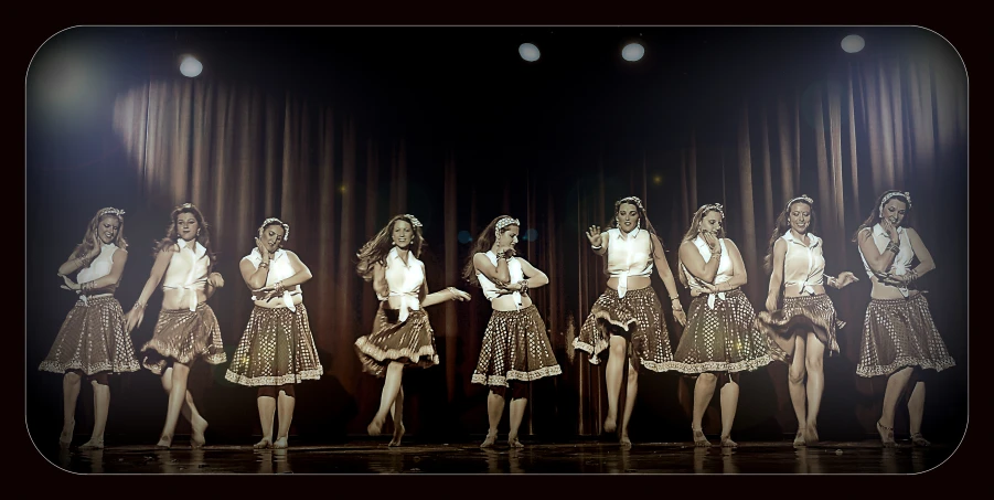 a line of girls on a stage at a fashion show