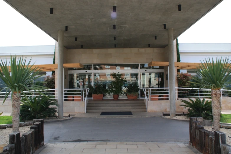 a large building with large plants in the front