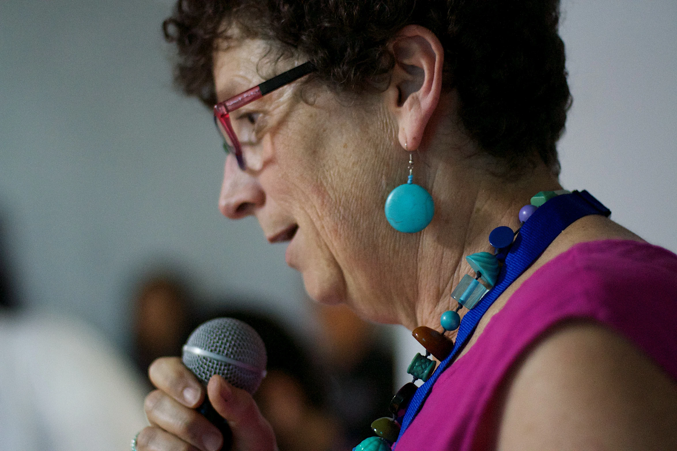 a woman holding a microphone speaking into it