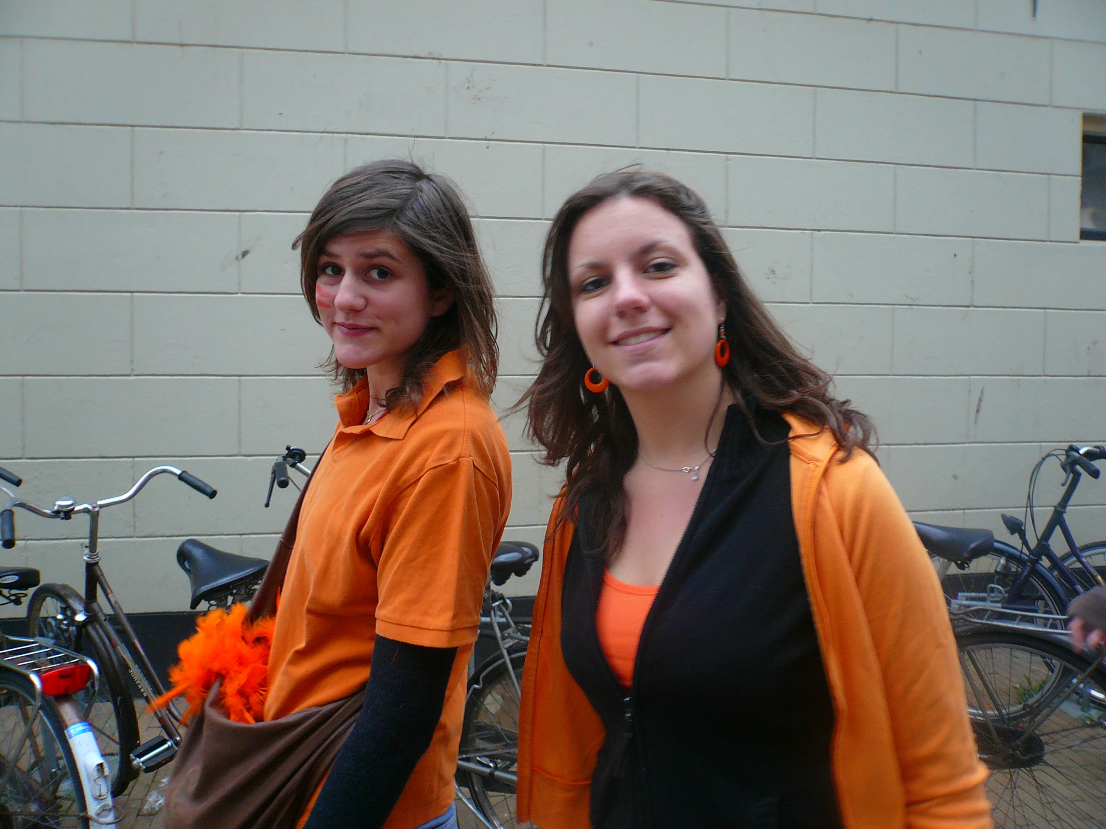 two women standing next to bicycles outside of a building