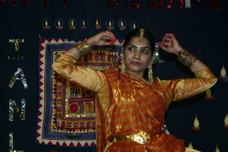 a woman with indian attire is holding up her hands