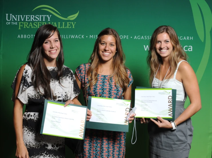 three girls are posing with awards and smiling