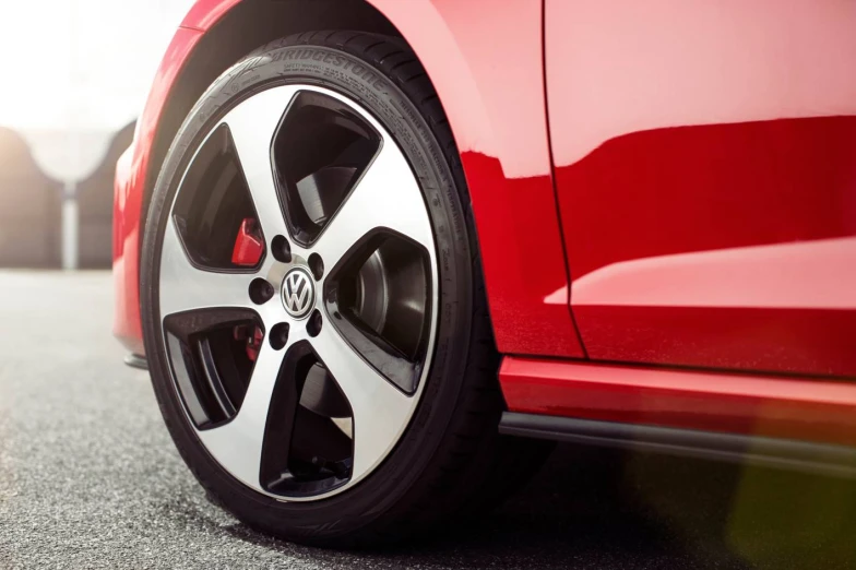 the back wheel of a red car on a road