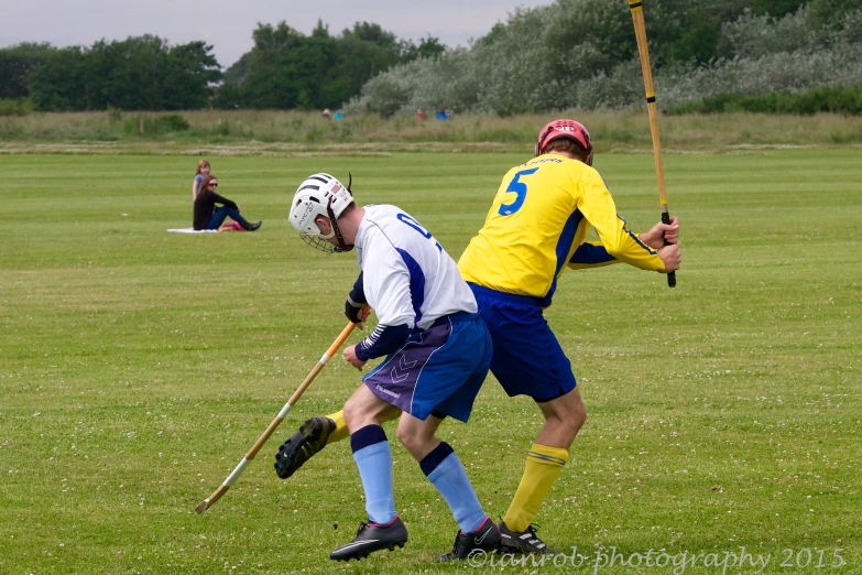 two players in action on the field, one trying to block the ball