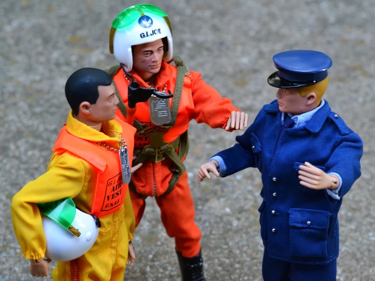 two toy workers, one is talking to two toy figurines
