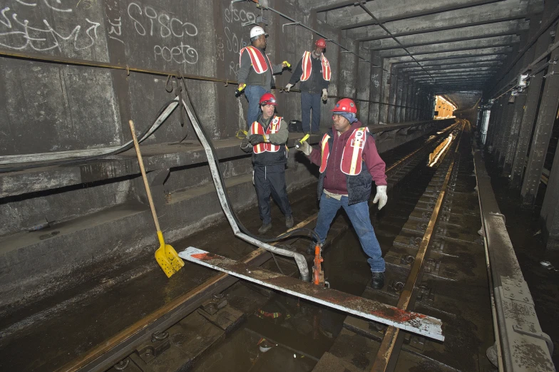 some workers are on a railroad track with their tools