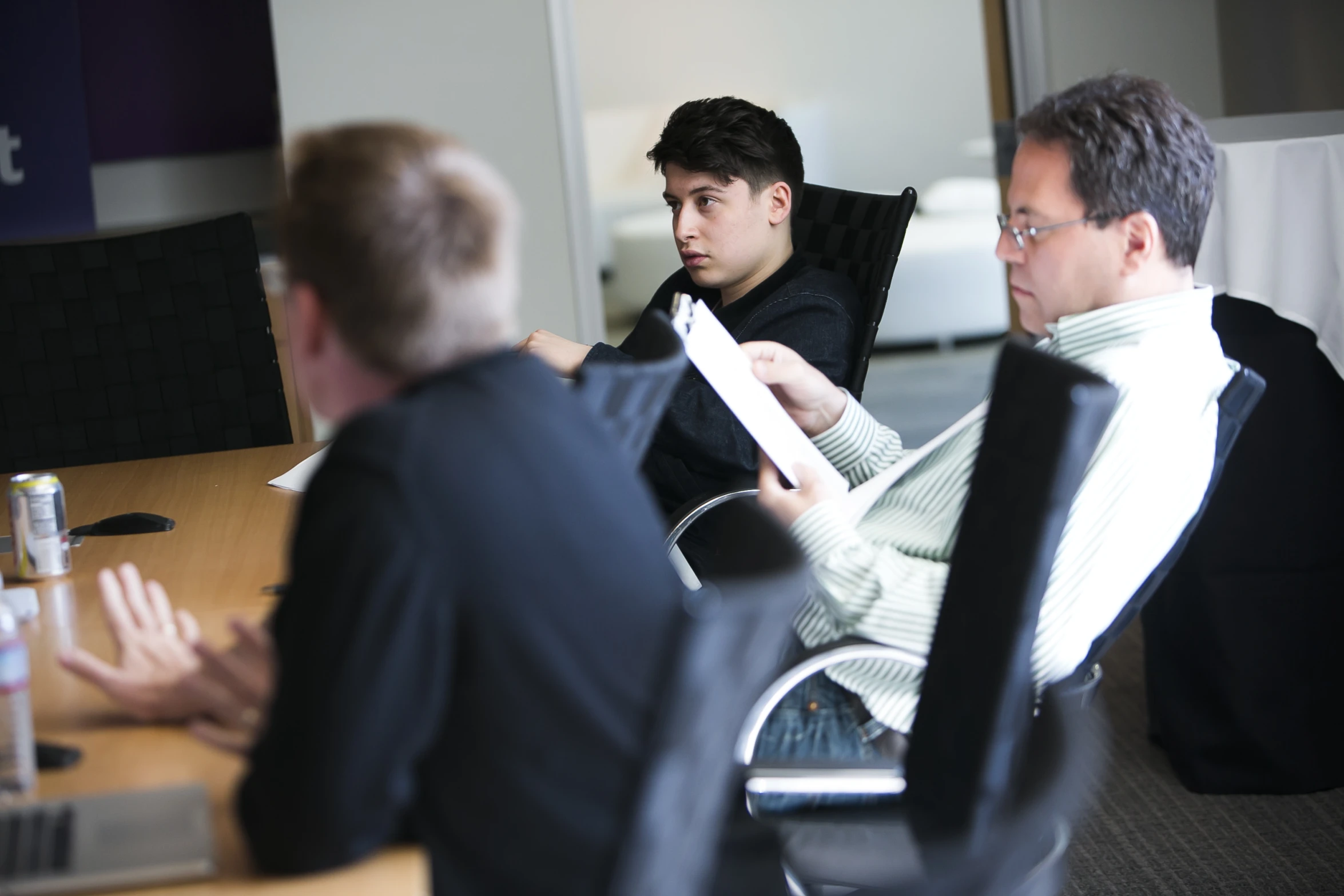 four men sitting in an office working together