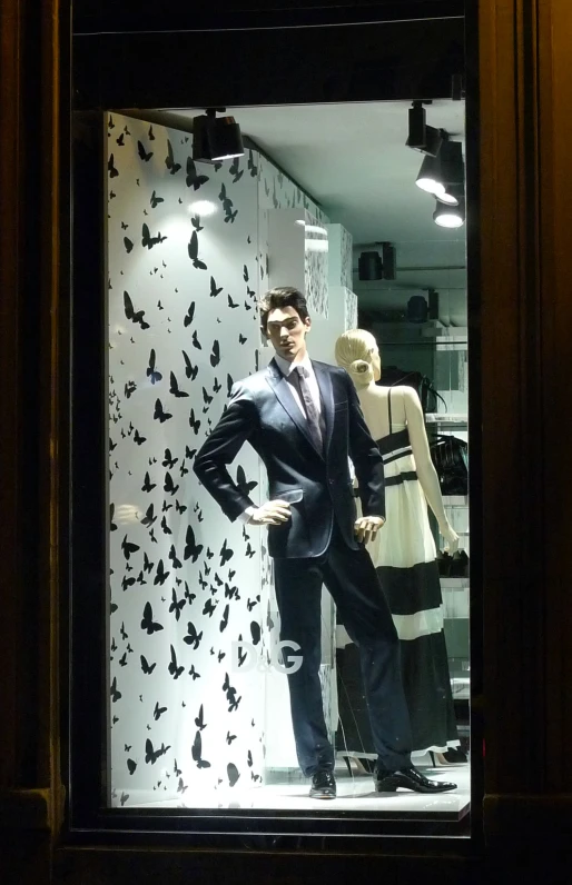 there is a male mannequin in the window with a suit on