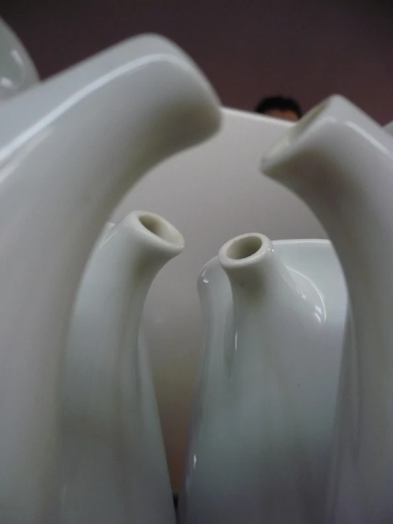 three white vases sit stacked next to each other