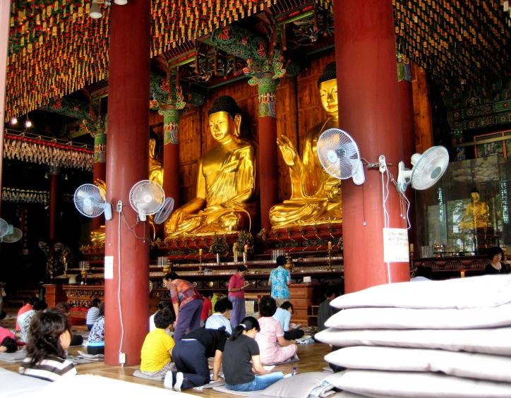 an asian shrine with a large gold buddha