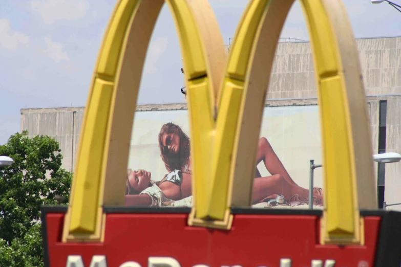 a mcdonald's sign and a model lying on a bench