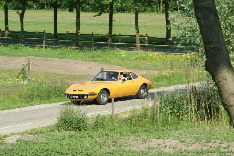 a yellow sports car parked on a rural road