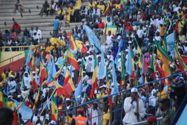 people standing around in front of some stairs and holding flags