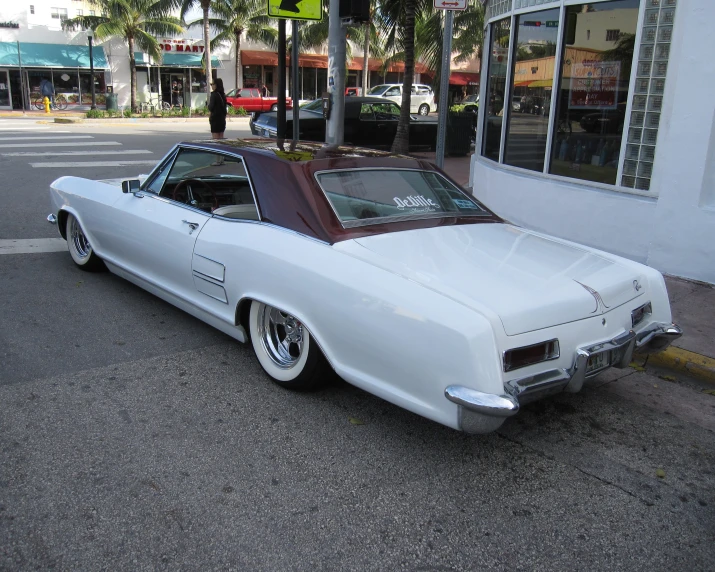 a very big nice looking car parked in front of a store