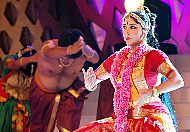 a young woman standing next to another young woman while others dance