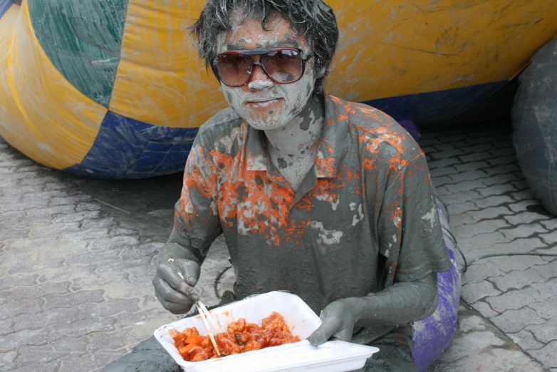 an old man with his face smeared like a creature is holding some food