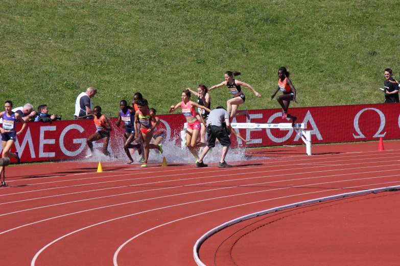 two men run behind other people in the rain on a track