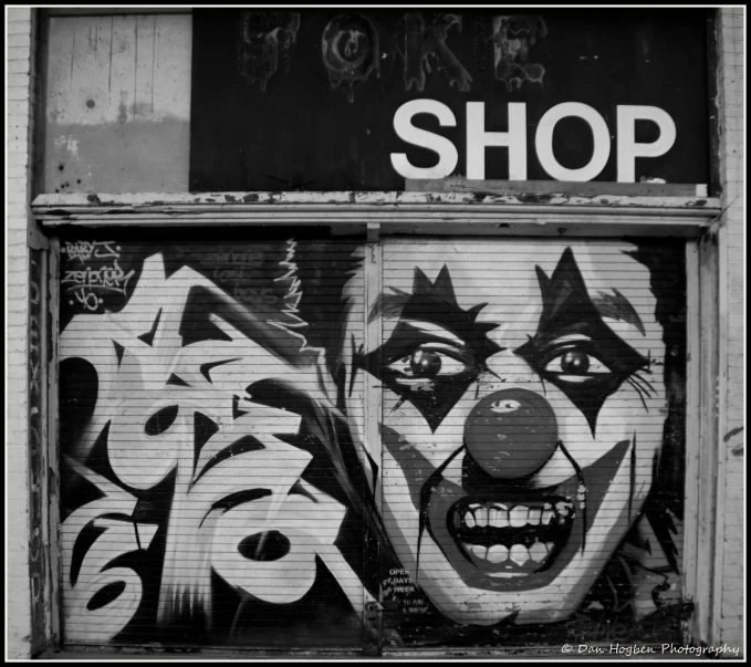 a graffiti - covered shop front with a painted joker face