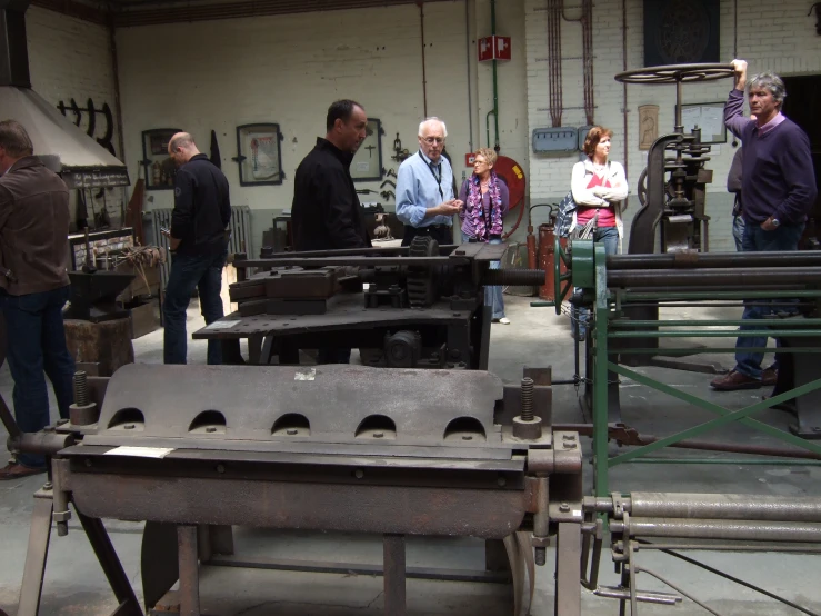 the people are working at the factory in front of machinery