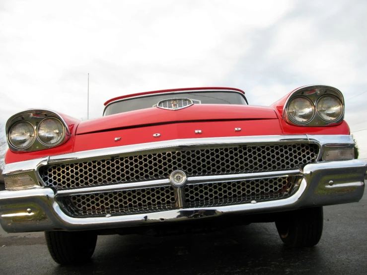 the front grille of a classic car in an empty lot