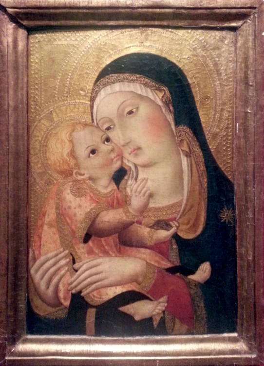 a golden framed painting with a lady holding a baby