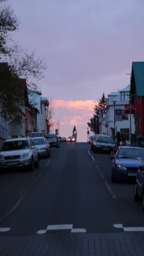 a street filled with lots of cars next to a building