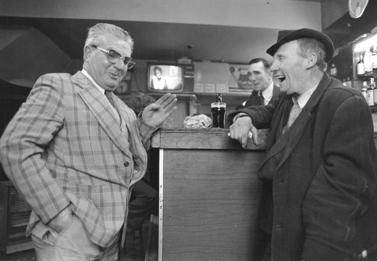 three men in a bar are greeting each other