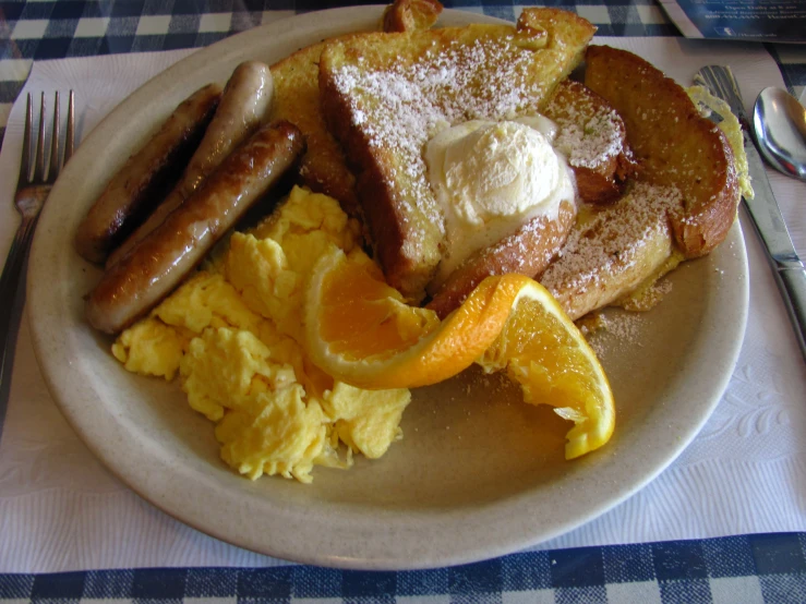 a breakfast plate that contains eggs, toast, and sausage